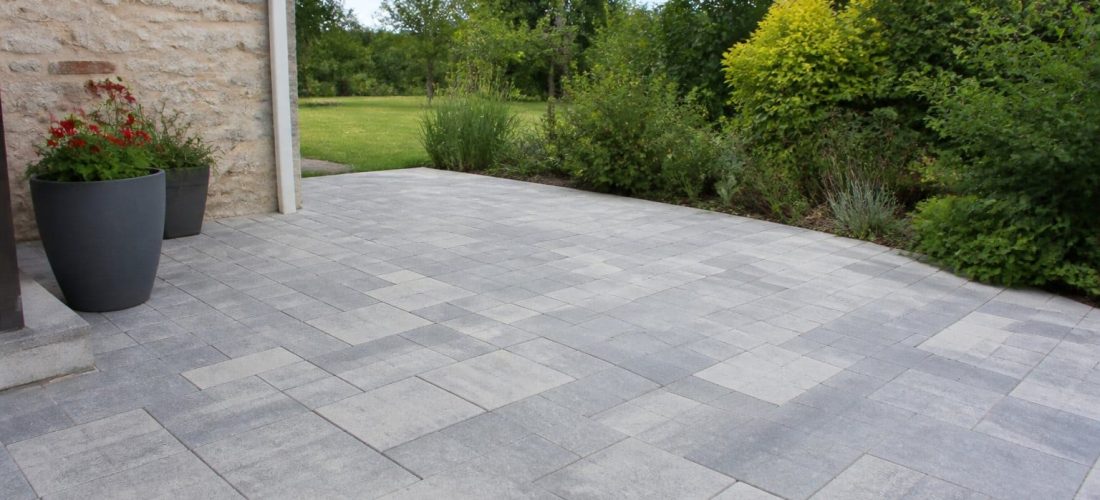 Terrasse extérieure aménagée avec des pavés béton gris